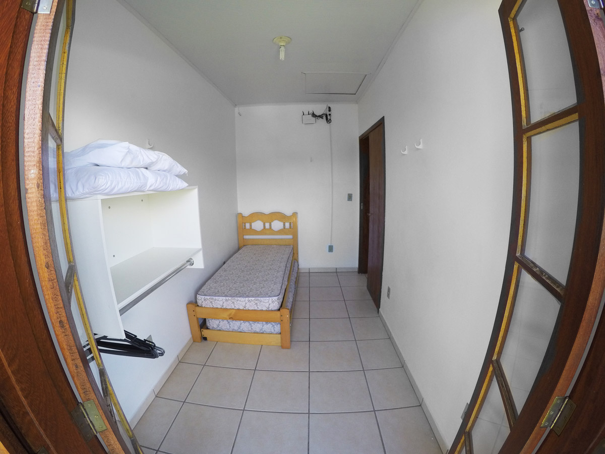 Detalhe decorativo com plantas em vasos e quadros na parede, iluminação realçando texturas; ambiente acolhedor