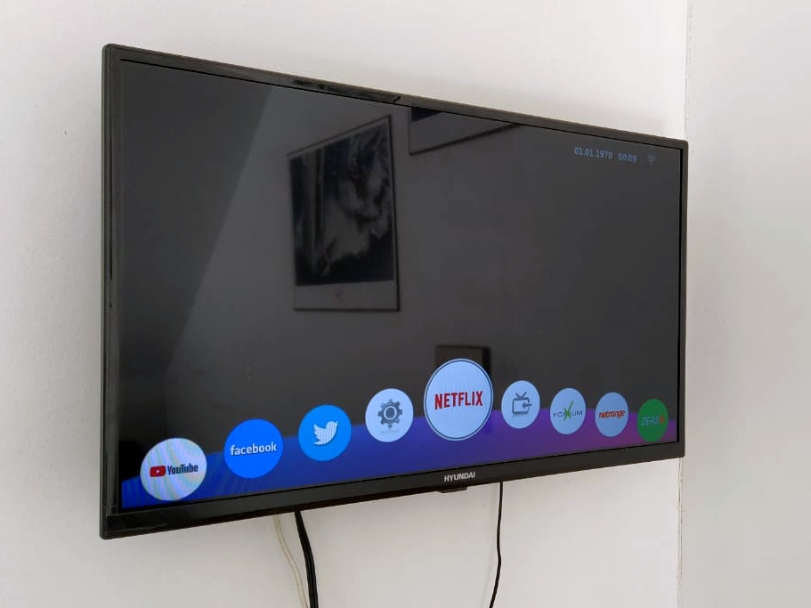 Vista lateral da cozinha mostrando bancada com liquidificador e utensílios organizados; ambiente funcional e limpo