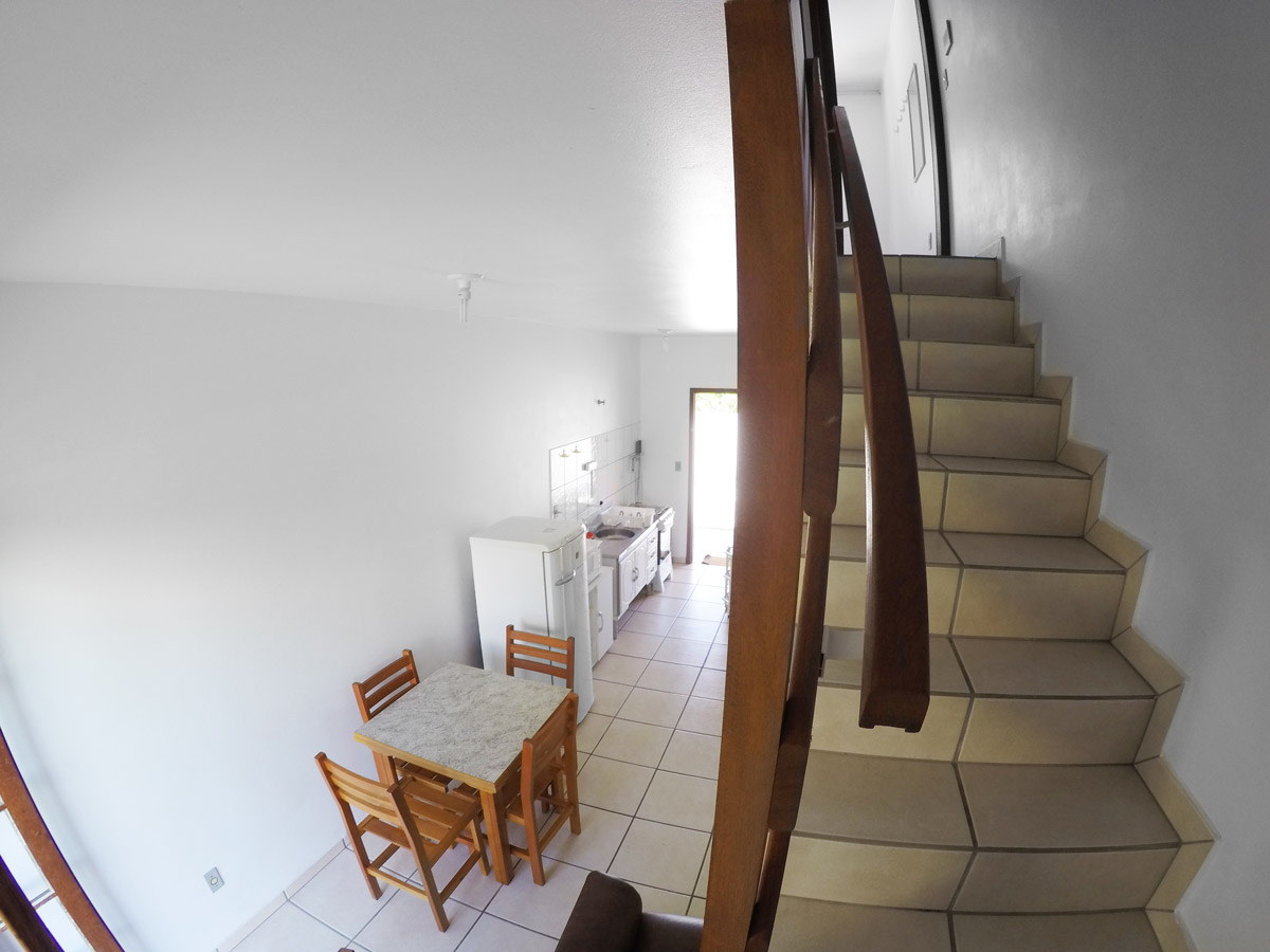 Banheiro com box de vidro, pia com gabinete e chuveiro elétrico; aparência limpa e funcional